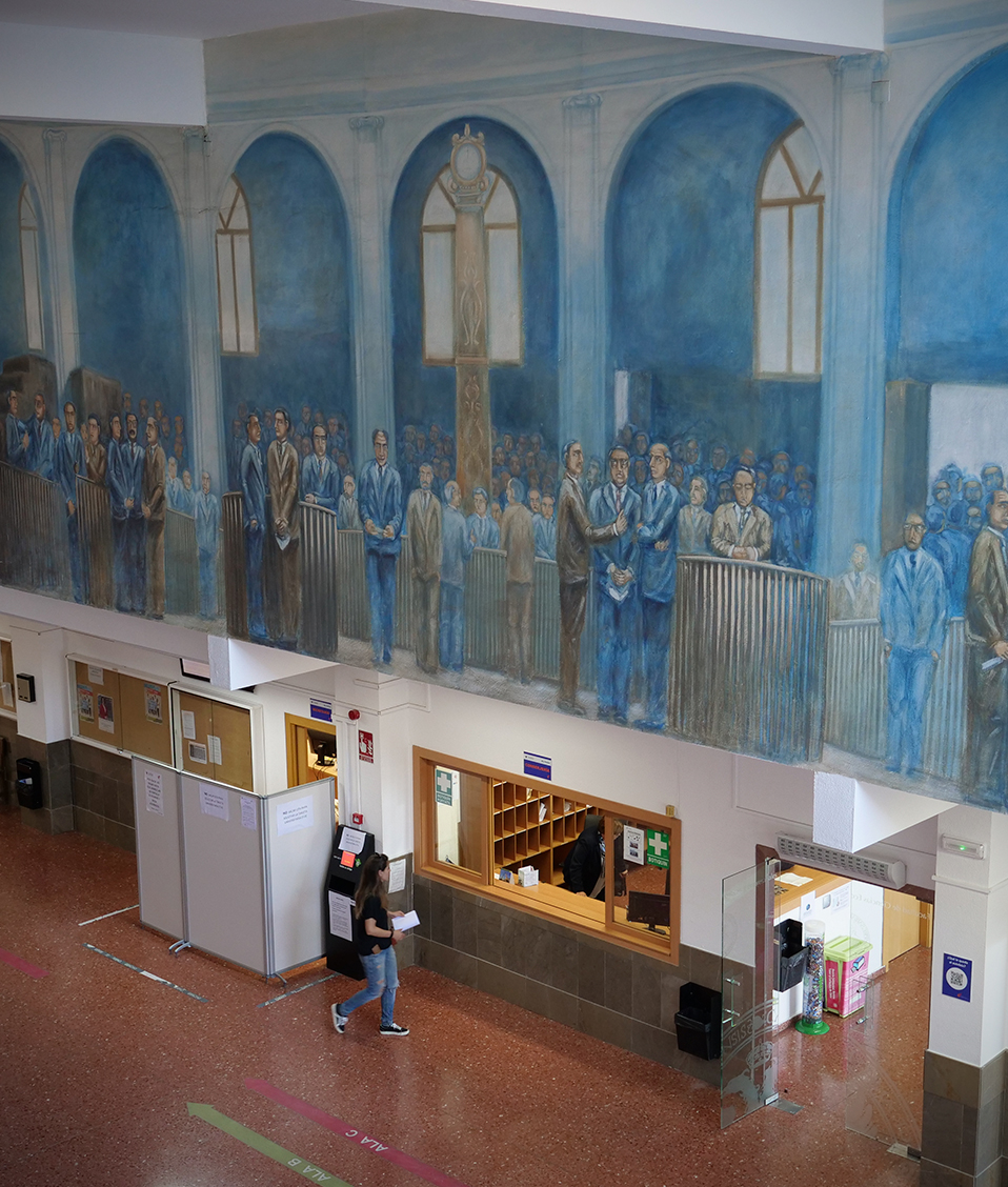 Alguna sala de la Facultad de Ciencias Económicas y Empresariales de Granada donde en la pared han pintado un cuadro de una gran múltitud de personas
